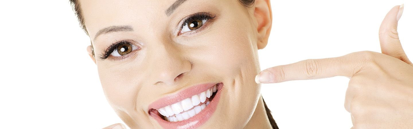 Eine Frau zeigt Ihre Zähne - Kiefergelenkstherapie